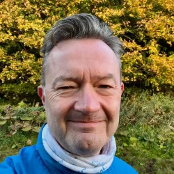 Tom Antonsen in exercise outfit in front of trees with autumn colours
