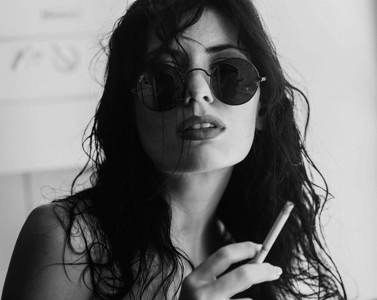 Illustration showing a young woman with sunglasses smoking a cigarette.