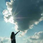 A woman standing on a hill, pointing up at a black cloud in an otherwise clear sky. AI-generated illustration.