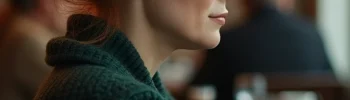 Sad but determined woman sitting at a cafe table.