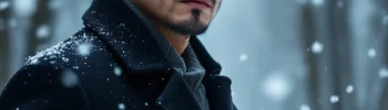 A man looking sad standing in a snowy forest.
