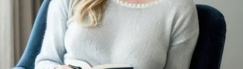 Woman sitting in a chair, wearing comfortable clothes, reading a book